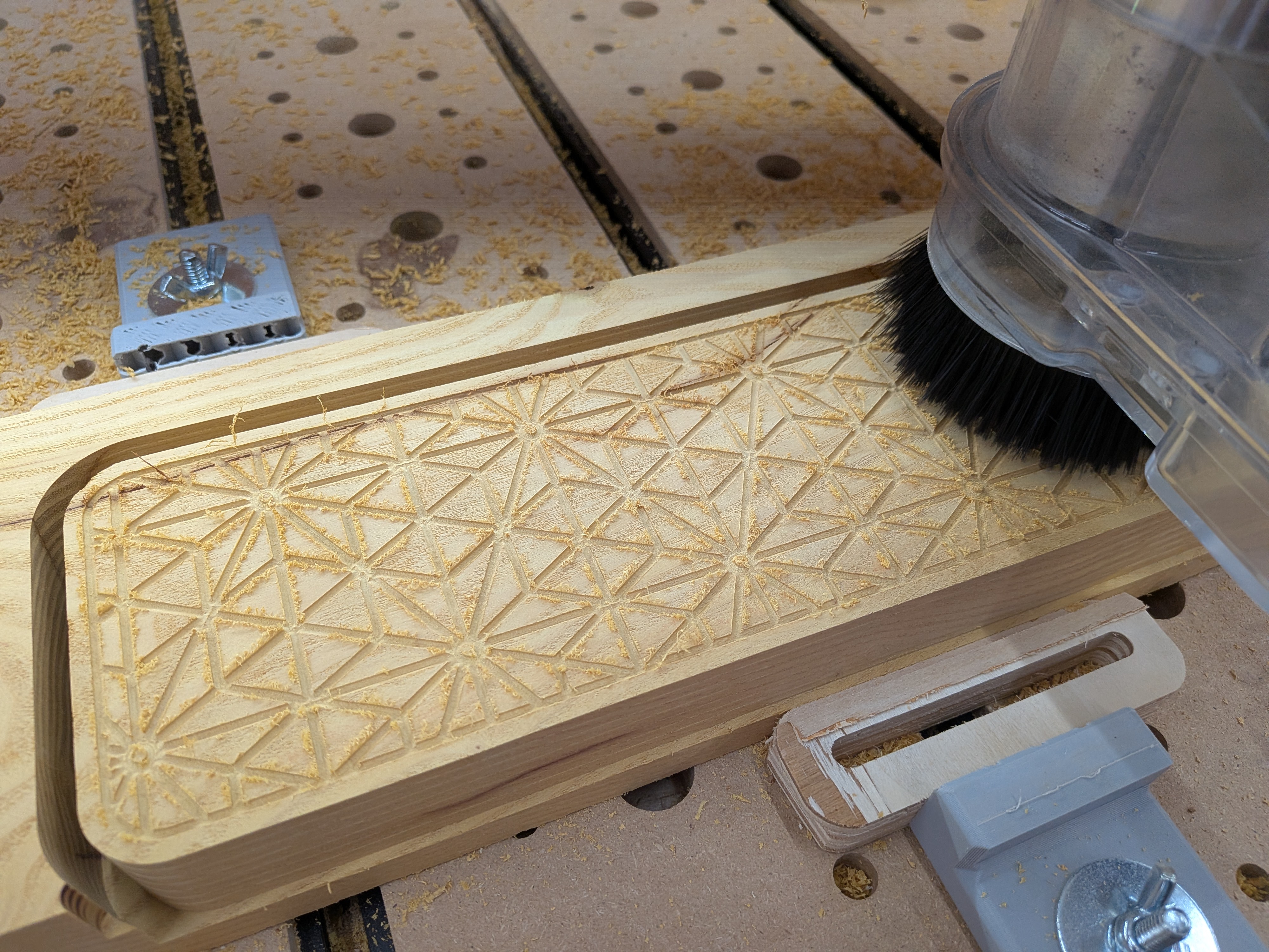 Asanoha pattern routed into the mulberry cover on the CNC – the geometric channels ready for epoxy